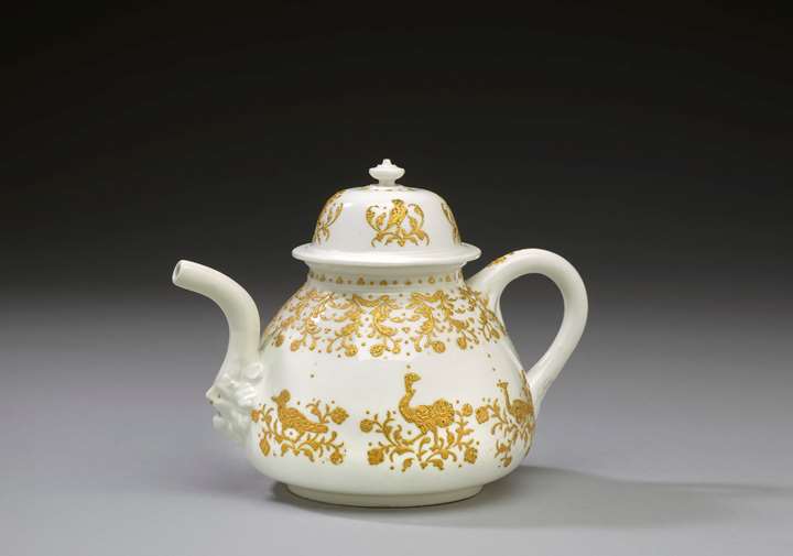 A tea pot decorated with animals and floral ornaments in gold relief enamel